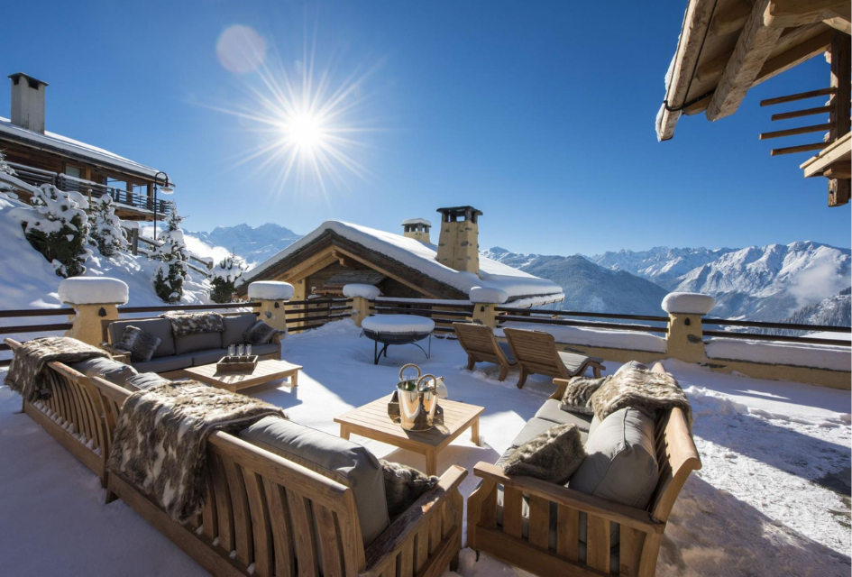 Outdoor Terrace area of Chalet Chouqui on a sunny day with snow, one of the best places to celebrate in this chalet.