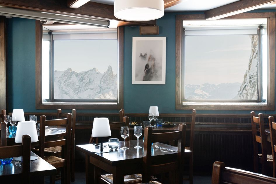 Interior of Le 3842 with views of mountain peaks through the windows, possibly the highest mountain restaurant in the Alps. 