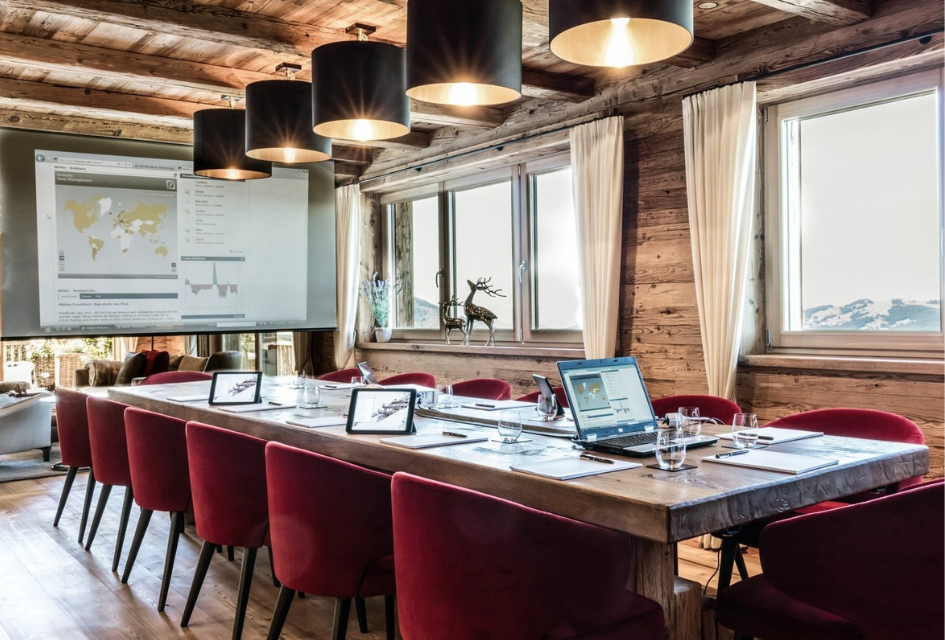 Corporate business meeting at Hahnenkamm Lodge at the dining table with mountain views.