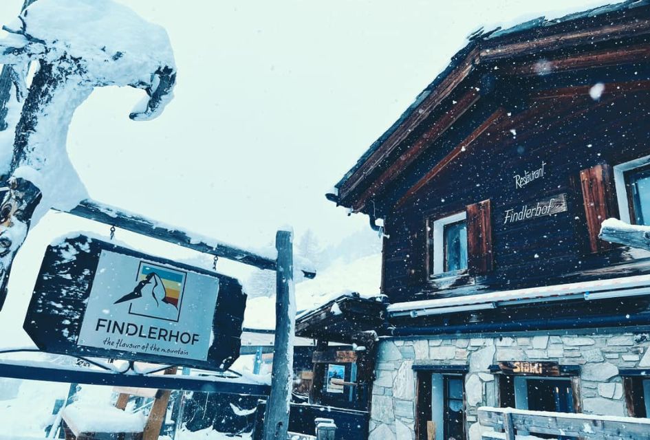 Exterior of Findlerhof restaurants, one of the top restaurants in Zermatt, with snow falling onto its sign.